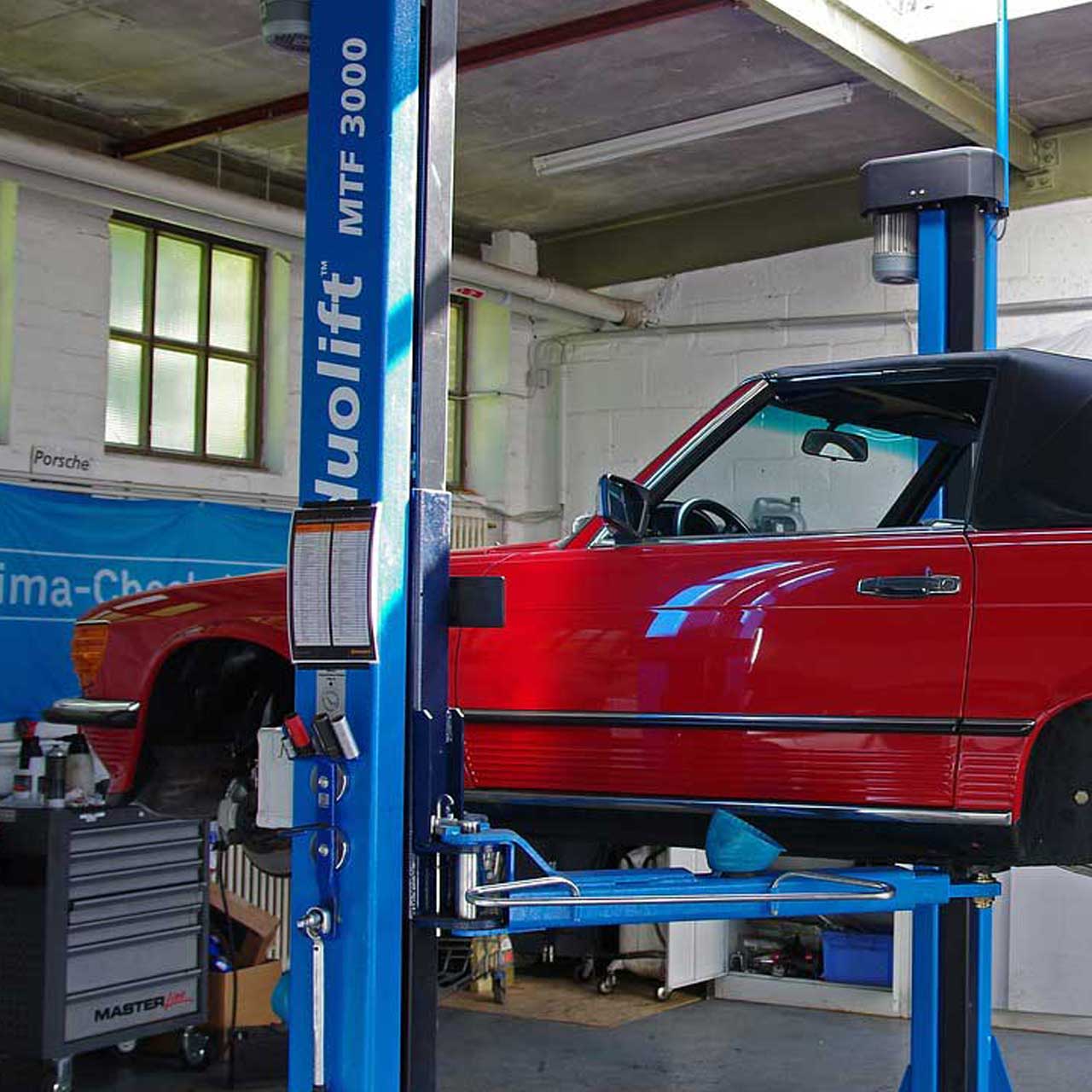 rotes Auto auf blauer Hebebuehne