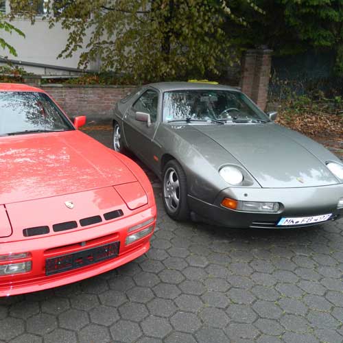ein grauer und ein roter Porsche